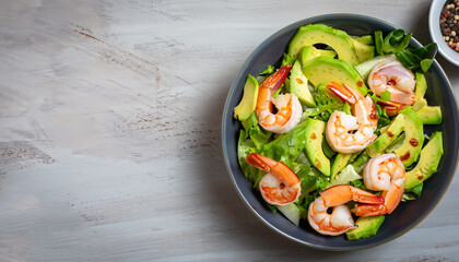 salad with avocado and shrimps in bowl, top view, copy space