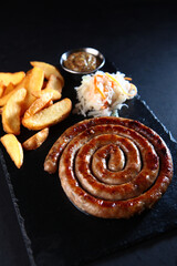 Bavarian beer appetizer. Smoked sausages on a wooden board. The concept of German cuisine. Meat sausages with sauce.