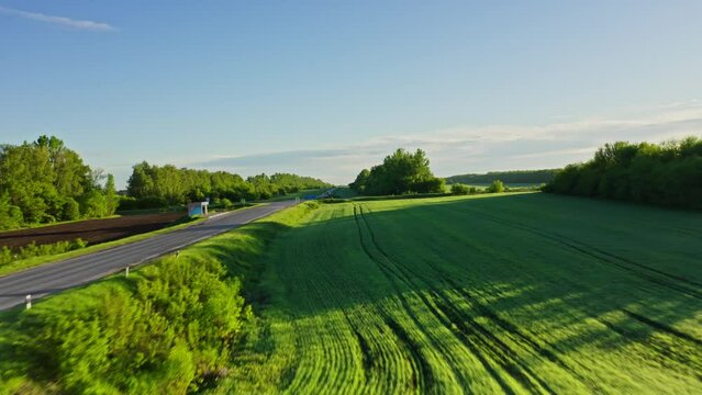 Aerial photography of the asphalt road in the middle of endless green fields and meadows in the central part of Russia