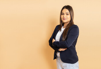 Portrait of beautiful young indian business woman wearing formal suit standing with her arms...