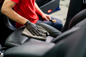 Detailing a man an employee of a car service station performs chemical cleaning and washing of a...