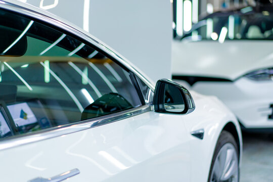 Detailing of the mirror and doors of a white luxury car after washing and dry cleaning in a car service or in a parking lot