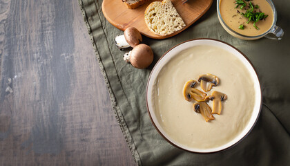 Fototapeta na wymiar Mushroom cream soup on rustic background, top view
