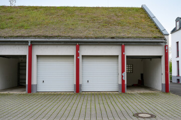 Garagenpark - Haus mit vier Garagen mit Garagentoren mit Gründach als Satteldach, Dachbegrünung