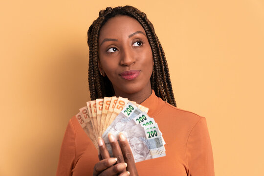 Thoughtful African American Woman Thinking And Looking To The Side In Beige Background. Economy, Payment, Successful Concept. 