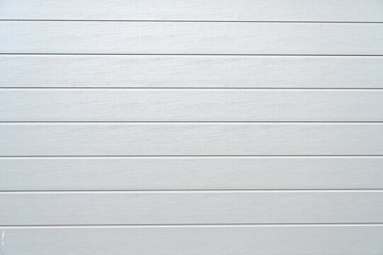 Wei&szlig;es Gargentor, Rolltor aus Metall mit waagrechten Streifen als Hintergrund, White garage door, metal roller shutter door with horizontal stripes as background