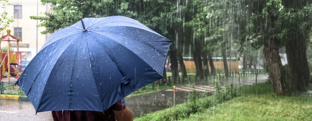 Heavy rain in the Park. Puddles on the sidewalk. Heavy raindrops fall into a puddle on the...