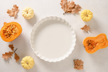 Autumn pumpkins, fall leaves, empty baking dish. Concept cook Pumpkin pie on white background. Top view. Thanksgiving Day.