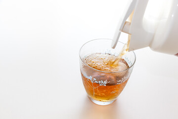 グラスに冷たいお茶を注ぐ