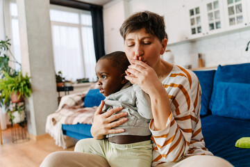 Mature woman holding and kissing her adopted child
