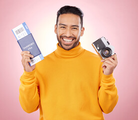 Happy asian man, portrait and passport with camera for travel or photography against a pink studio background. Male person or photographer smile with ticket for flight trip, photo or vacation memory