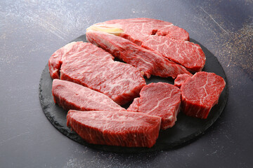 Raw beef on a black plate