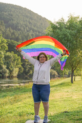 middle aged woman holding lgbtq flag