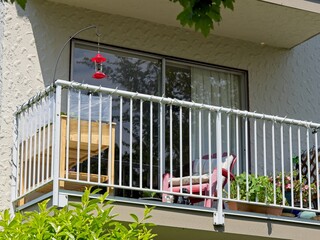 Residential balcony of an apartment building with hummingbird feeder