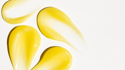 Smears of yellow cream, balm, conditioner with banana, egg or chamomile on a light background. there is an empty space.