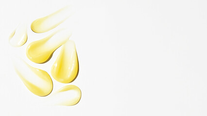 Smears of yellow cream, balm, conditioner with banana, egg or chamomile on a light background. there is an empty space.