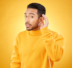 Gossip, whisper and man portrait with hand on ear in studio for speak up body language on yellow background. Secret, listen and face of guy with privacy, news or confidential coming soon promo