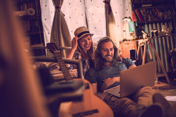 Young couple using a laptop in a bedroom