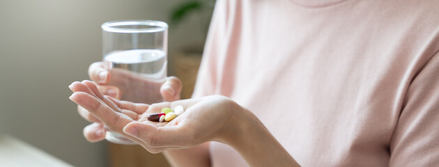 Healthcare Harmony: Close-Up Hands Holding Medication and Water Glass for Optimal Wellness,...