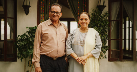 Fototapeta na wymiar Portrait of Happy Indian Elderly Couple Posing Together at Their Authentic Mumbai Home. Senior Husband and Wife Celebrating Shared Years of Love and Appreciation, Looking at the Camera