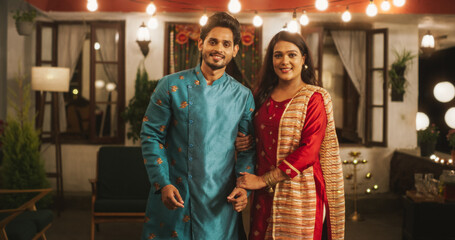 Obraz premium Portrait of Happy Indian Young Couple in Traditional Clothes and Posing Together. Newlywed Husband and Gorgeous Wife in Love Looking at the Camera, Happy and Celebrating Diwali
