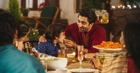 Fototapeta na wymiar Family Time and Good Happy Memories: Indian Father Feeding his Son and Sharing Traditional Food on a Family Dinner. Family Bonding Memories Full of Love and Affection