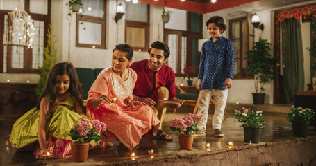 Portrait of an Indian Family Celebrating Divali by Putting Lamps in Their Backyard. Happy Young...