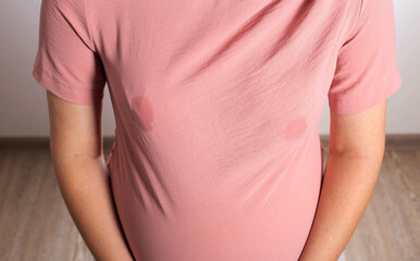 A soaked blouse from milk on the female breast of a nursing mother. Leak-proof bra pads, close-up