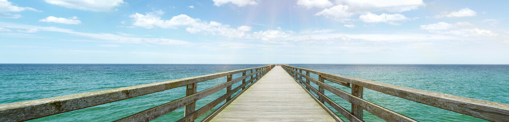 Fototapeta na wymiar Wooden landing walkway at the sea with view to the water