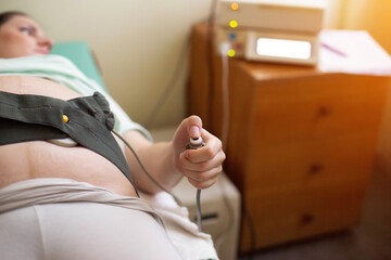 A pregnant woman undergoes a medical examination. Cardiotocography for an infant. A method of...