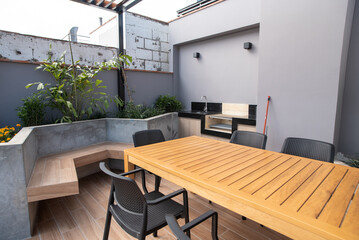 zona de parrilla y comedor en terraza de edificio de departamentos