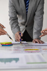 Business team meetings using calculators and laptops Work with charts and analyze business strategies, financial statistics, company accounts sitting at a table, vertical view.