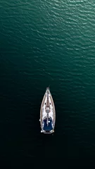 Foto op Canvas Top down aerial view of a sail boat sailing towards the light © teamjackson