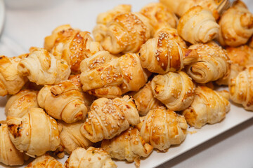white plate with mini croissant, appetizers and party snacks.