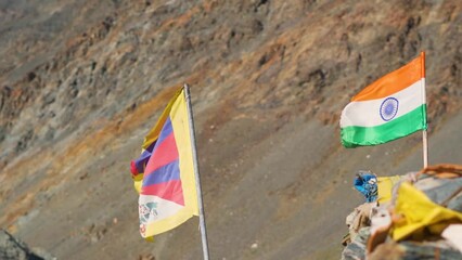 Closeup shot of Indian flag waving along side the Tibetan flag at Spiti Valley in Himachal Pradesh, India. 