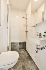 a bathroom with a sink, toilet and shower head mounted on the wall in it's corner to the left