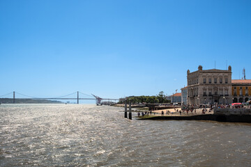 Fototapeta na wymiar Stadtstrand in Lissabon, im Hintergrund die Brücke des 25. April