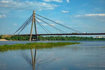 Fototapeta na wymiar Panoramic landscape view bridge across Dnipro River in Kyiv, Ukraine. Pivnichnyi (Northern) bridge, cable-stayed bridge across the Dnipro. Infrastructure of a big city concept. Sunny summer day