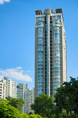 Obraz premium Low-angle view of modern high rise residential building. Blue sky with white clouds in the background. Modern architecture from glass and steel. Concept of real estate in Kyiv, Obolon neighborhood