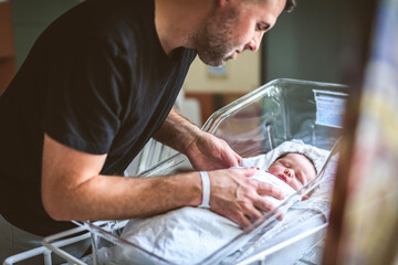 New born baby boy resting in little bed in hospital - obrazy, fototapety, plakaty