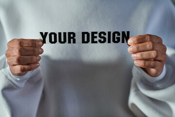 Cropped view of african american craftswoman in sweatshirt holding printing layer with your design lettering in print studio, focused business owner managing workshop