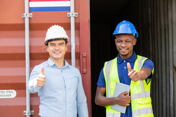 Engineer or logistic foreman with colleague worker smiling and showing thumbs up at container...