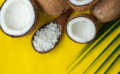 Fresh and healthy coconut image isolated on yellow background, coconut flakes with palm leaf