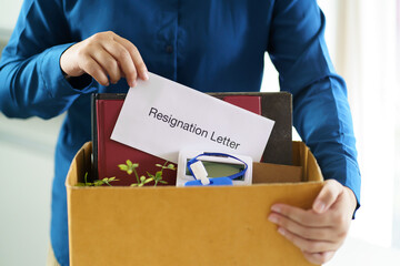 Fototapeta na wymiar Quit Job Business man sending resignation letter and packing Stuff Resign Depress or carrying business cardboard box in office. Change of job or fired from company.