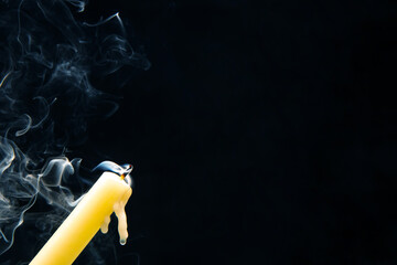Smoke from an extinguished candle on a dark background. The concept of spirituality and the end of...