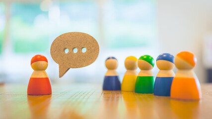 Wooden model of people standing on a wooden table with communication symbols. The concept of...