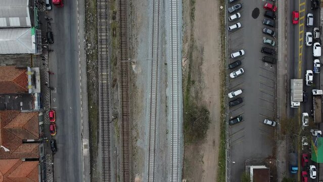 Vis&atilde;o a&eacute;rea do tr&acirc;nsito da cidade de Suzano SP Brasil captada do alto entre as avenidas e a linha de trem com passagem de um trem. 