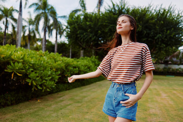 Fototapeta premium walk woman park t-shirt beautiful summer bag smiling lifestyle nature freedom