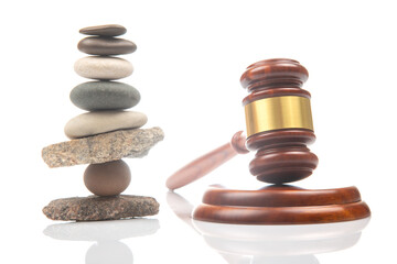 pyramid of stacked stones and a gavel of justice and law on a white background. stabilization and...