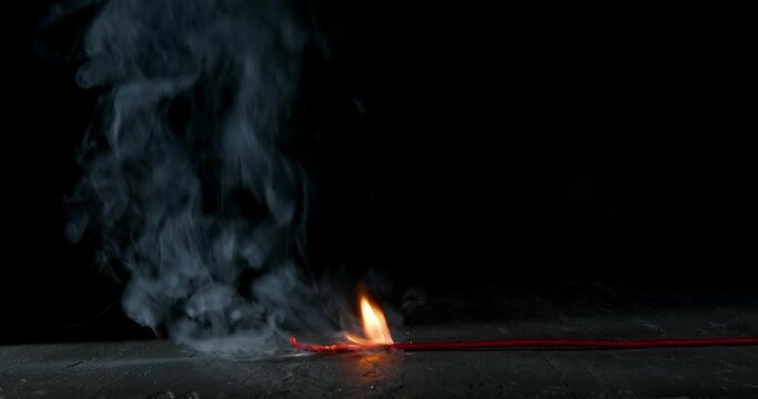Following the lit fuse of a round black bomb burning, sparking, and smoking. Bomb about to detonate symbolizing destruction, threats, or dangerous violence.